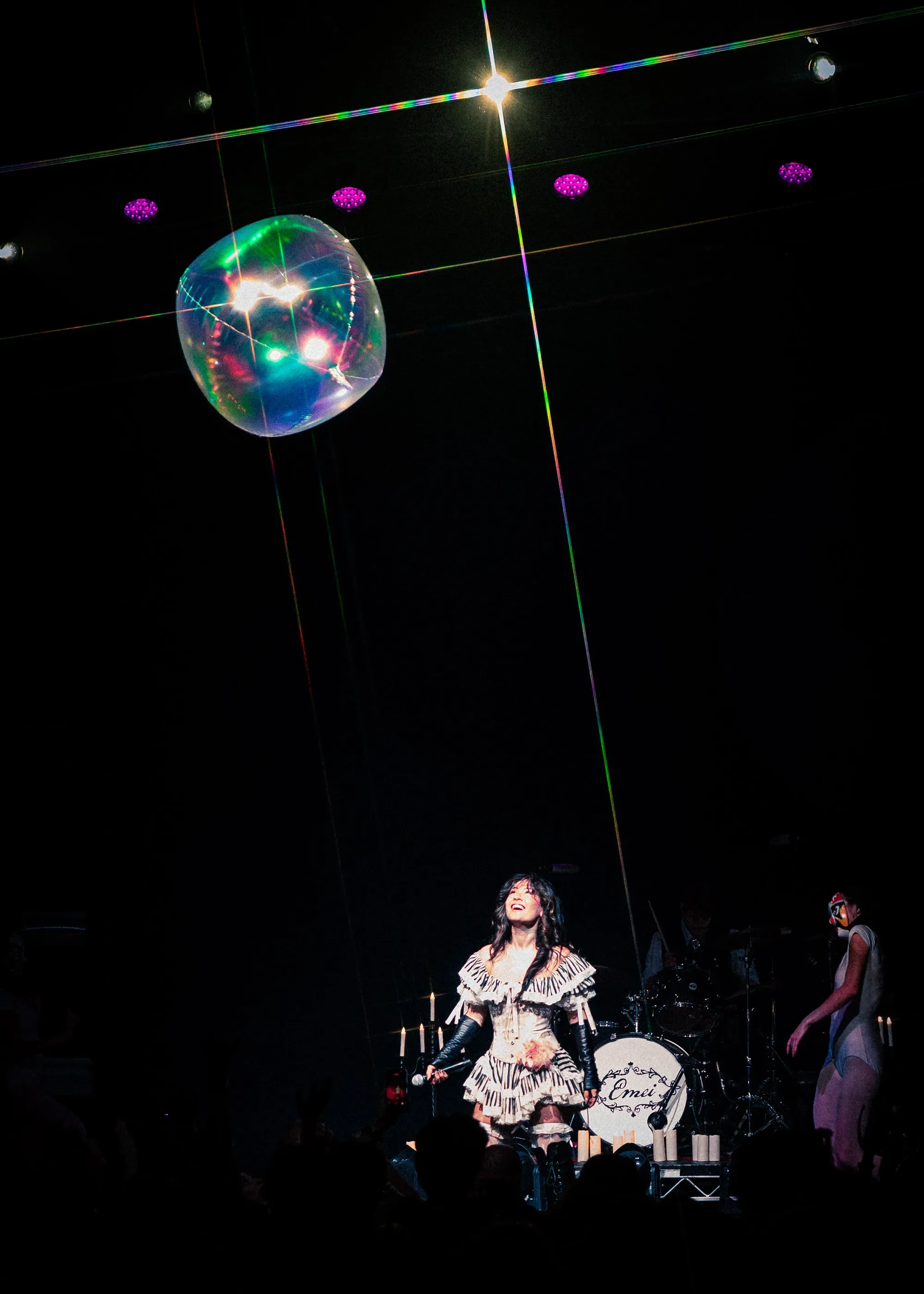 A large transparent inflatable ball floats above the audience as Emei smiles onstage at Vogue Theatre.