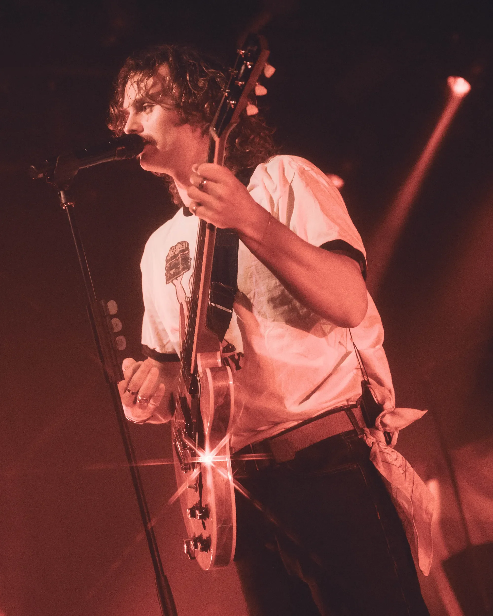 Evan Honer at the mic under red stage lighting at Commodore Ballroom