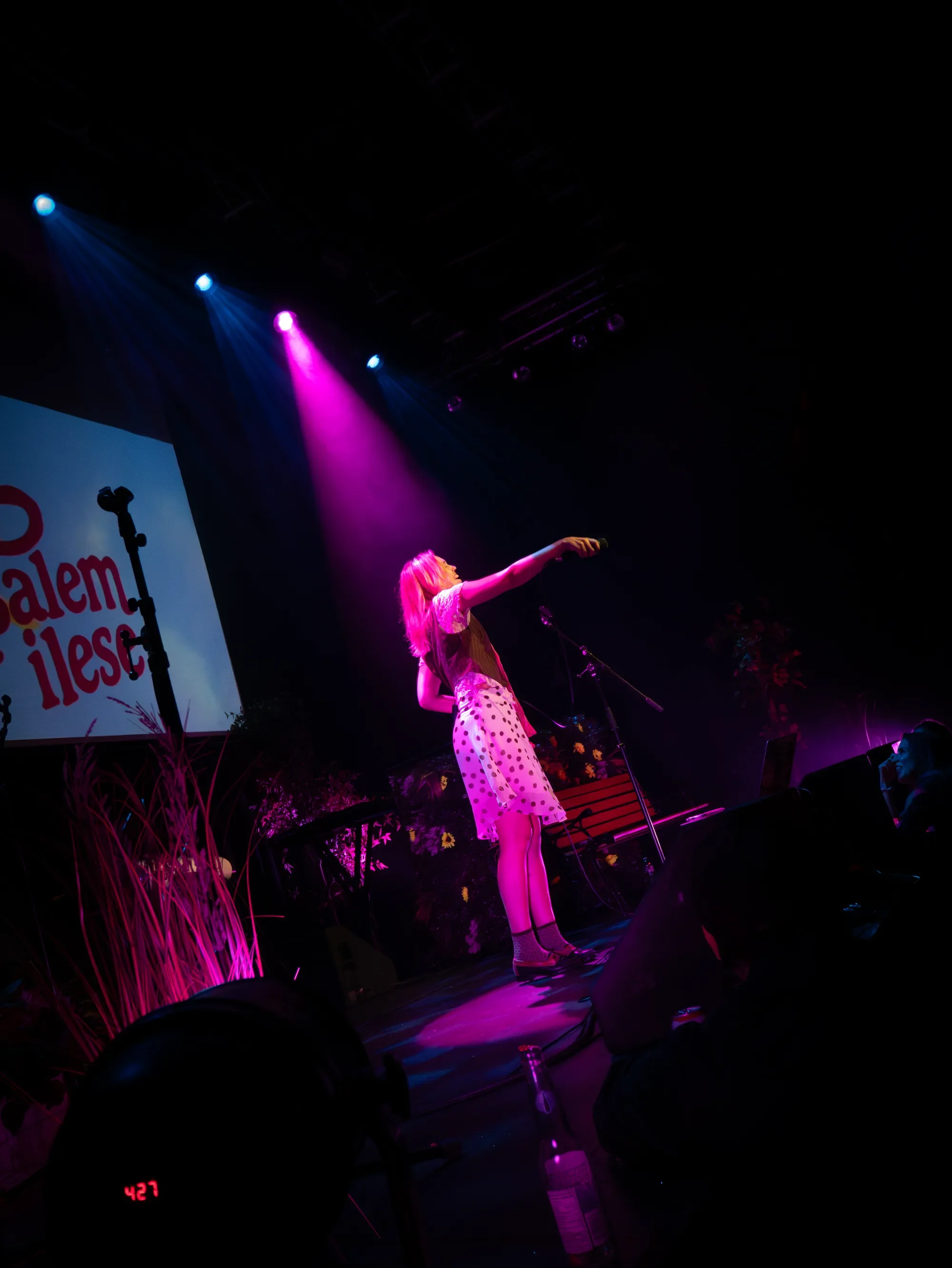 salem ilese reaches toward the crowd under pink and blue lights, with her name projected behind her at The Pearl.
