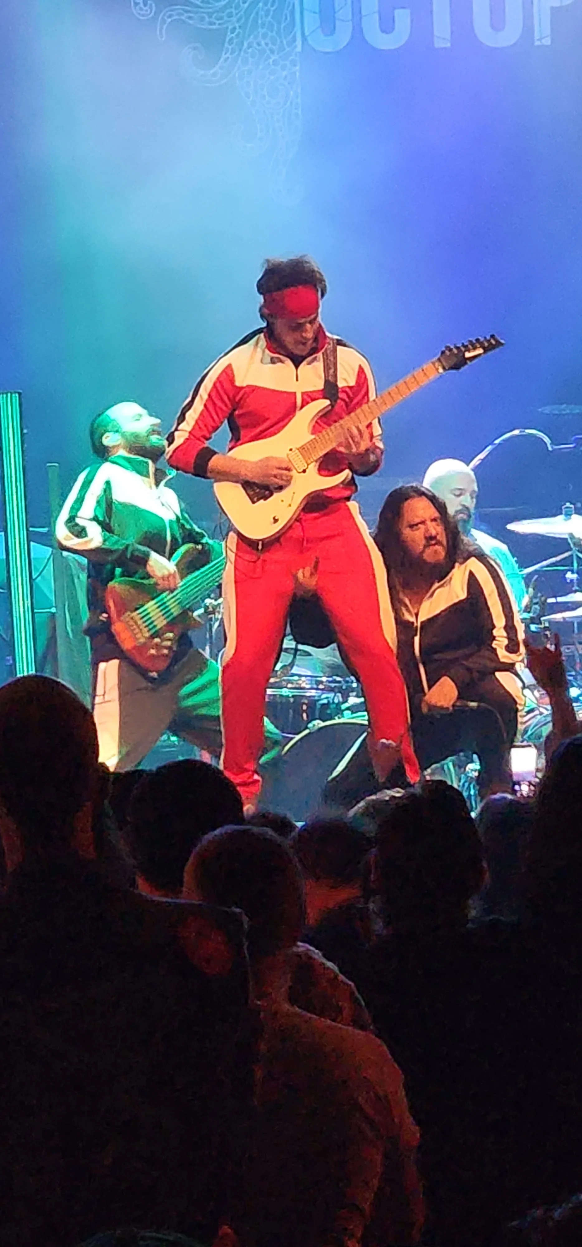 Cyborg Octopus guitarist in a red tracksuit playing a white guitar onstage at Rickshaw Theatre.